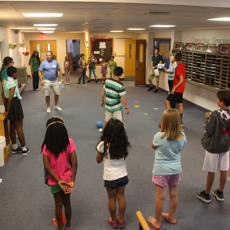 Adults and children playing games together.